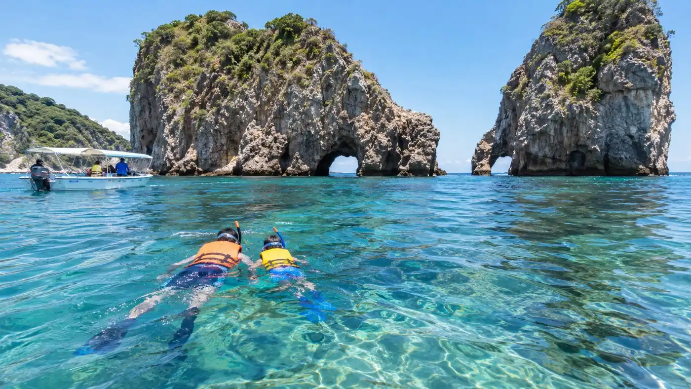 Une famille faisant du snorkeling ensemble dans une eau calme et peu profonde, près d'îles de granite
